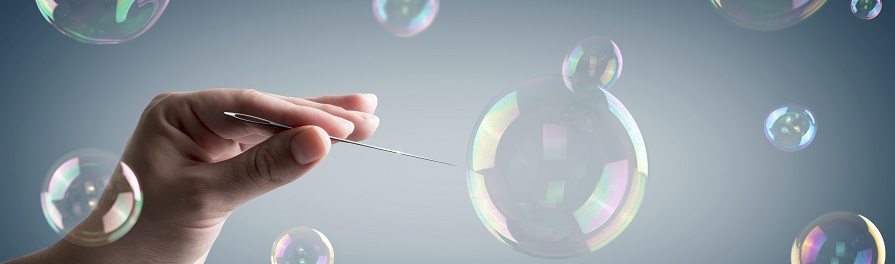 hand with a needle that breaks a soap bubble